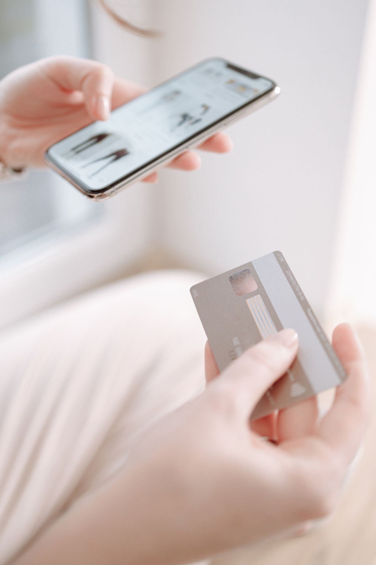 スマートフォンとカードを持つ手元